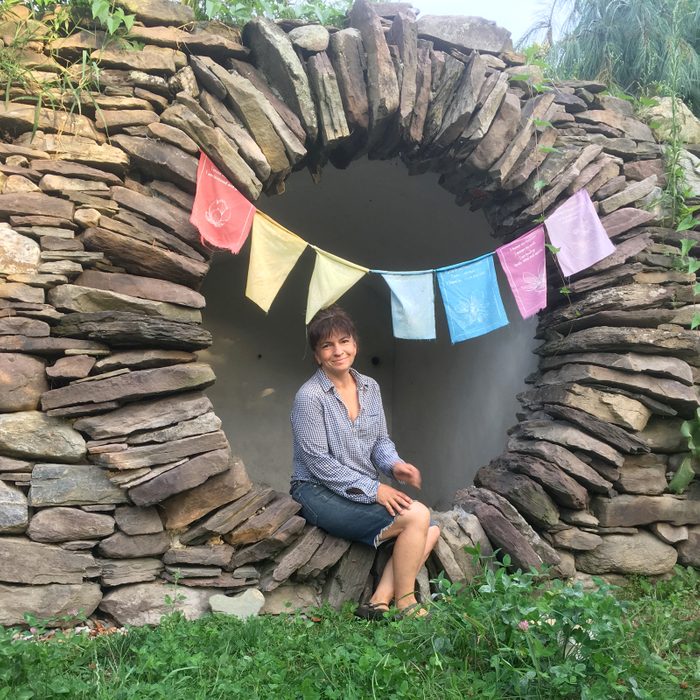 Thea Alvin sitting in a stone arch