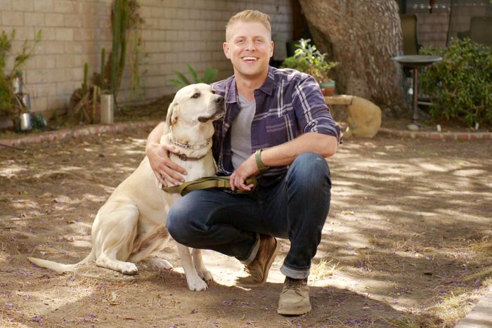 Luke bar sitting outside with a yellow lab dog